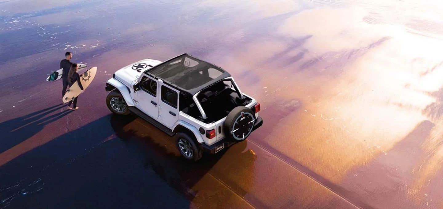 2026 Jeep Wrangler Sport S style SUV parked on a forest trail with doors removed for open-air Jeep driving