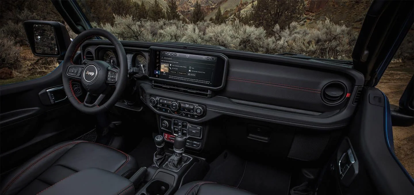 2026 Jeep Wrangler interior dashboard with infotainment touchscreen showing trail map graphics
